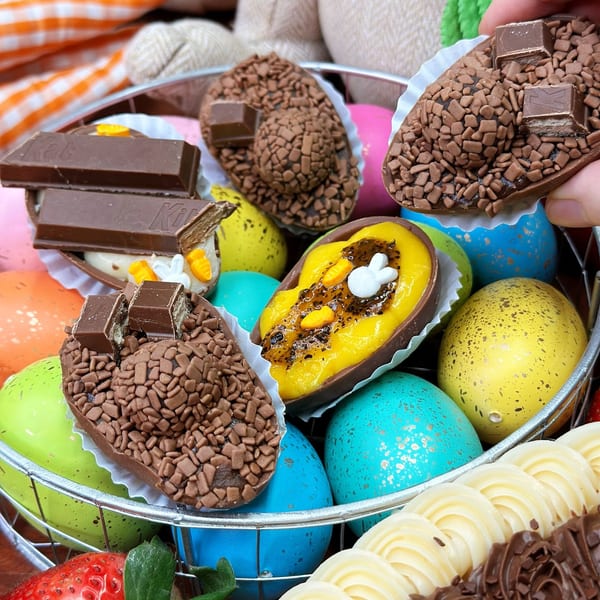 A basket of colorful Easter eggs and chocolate brigadeiro half-eggs with various toppings.